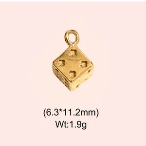 Close-up of vintage gold-plated stainless steel dice charm with clover cutouts