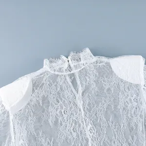 Gros plan détaillé du tissu en dentelle florale blanche d'une robe à col montant