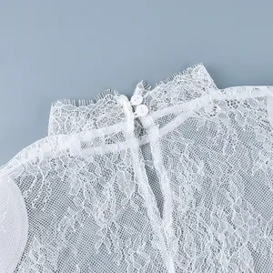 Détail du col montant en dentelle blanche élégante avec fermeture boutonnée au dos.