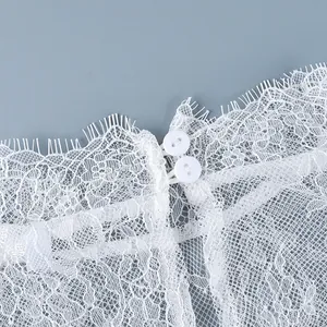 Gros plan détaillé sur la dentelle florale blanche et les boutons d'une robe chic