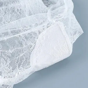 Détail en gros plan d'un tissu en dentelle florale blanche pour robe élégante