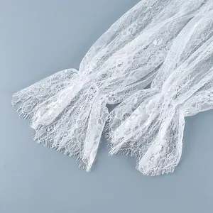 Gros plan sur le tissu en dentelle florale blanche avec bords à franges délicats.