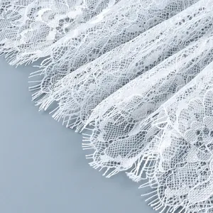 Gros plan sur les détails complexes de la dentelle blanche aux motifs floraux délicats