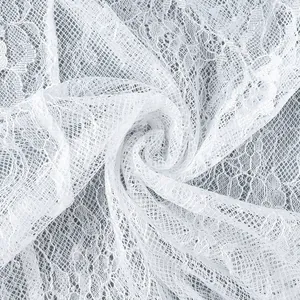 Vue détaillée du tissu de dentelle florale blanche avec un motif de maille translucide.