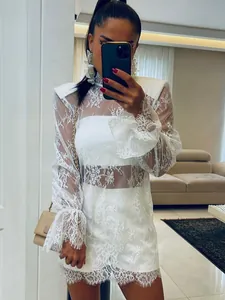 Robe courte élégante en dentelle blanche transparente à manches longues et col montant.