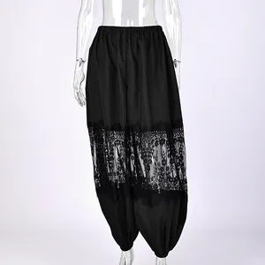 Dettaglio di pantaloni jogger neri ampi con pizzo elegante e polsini elasticizzati
