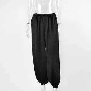 Vista dettagliata dei pantaloni harem neri larghi da donna con vita e caviglie elasticizzate.