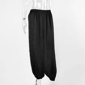 Dettaglio dei pantaloni harem neri da donna con vita elastica e polsini raccolti.