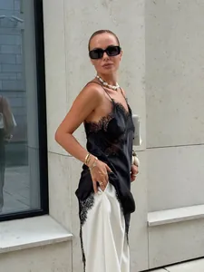 Détail rapproché de la robe nuisette en satin noir avec dentelle et fente latérale