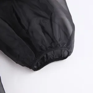 Dettaglio del polsino in rete nera trasparente di questa elegante camicia da donna