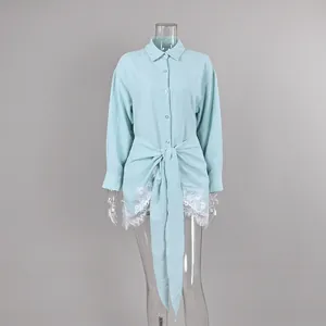 Detail view of a light blue long sleeve shirt with lace trim and elegant front tie waist