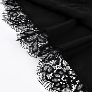 Detaillierte Makroansicht der zarten Wimpernspitze an einem schwarzen asymmetrischen Camisole-Top