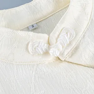 Close-up of traditional Chinese frog button and jacquard texture on white shirt