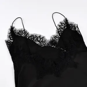 Nahaufnahme des eleganten Wimpernspitzen-Ausschnitts an einem schwarzen Satin-Top.
