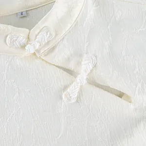 Detail of ivory New Chinese style blouse showing jacquard texture and frog buttons
