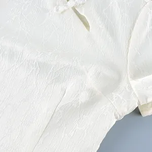 Detail macro view of textured white fabric and traditional frog button on blouse