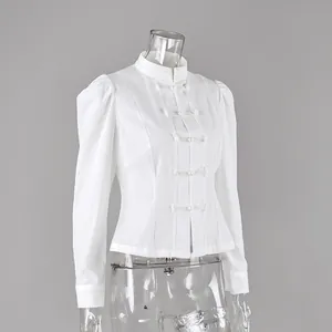 Detalle de camisa blanca de manga larga con cuello mandarín y botones chinos.