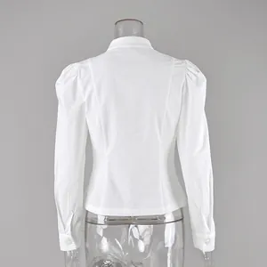 Vista trasera detallada de camisa blanca entallada con hombros abullonados y cintura elegante