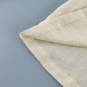 Detailed close-up showing fine stitching and linen fabric texture on a beige blouse.