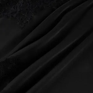 Detailaufnahme des schwarzen Satinstoffs und der zarten Wimpernspitzenverzierung am Oberteil.