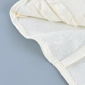 Close-up view showing the intricate fabric texture and clean hemline of this white shirt