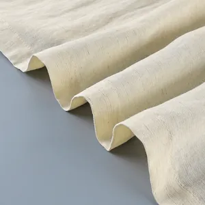 Macro view of beige linen-like fabric detail showing the soft folds and delicate stitching