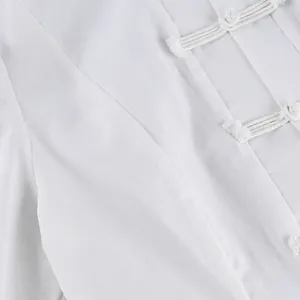 Primer plano de una blusa blanca de estilo chino con cierres tradicionales de nudo