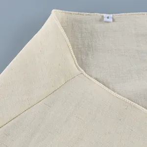 Close-up detail view of the cream linen-like wrap shirt neckline with size S label