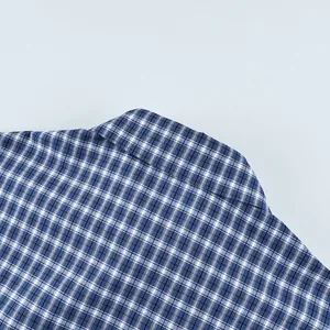 Macro view of blue plaid cotton shirt collar showing fine stitching and fabric texture