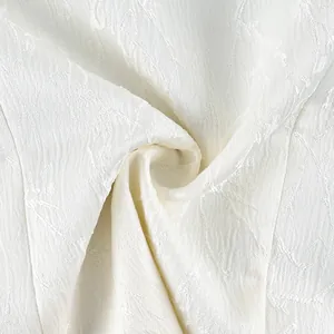 Macro detail showing the elegant white jacquard fabric texture with branch patterns