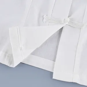 Primer plano de camisa blanca de estilo chino con cierre tradicional de botón de rana