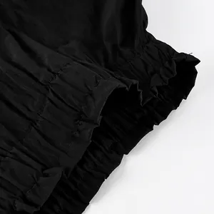 High-quality close-up of the delicate ruffle hem detail on a black tiered skirt