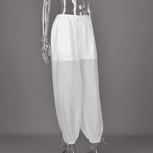 Detail of white semi-sheer drawstring pants with adjustable cuffed hem.