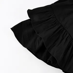 Detailed close-up view of a black high-waisted tiered skirt with ruffled layers.