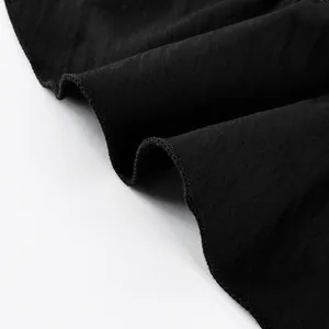 Close-up of the black ruffled hem and delicate stitching on a tiered skirt fabric.