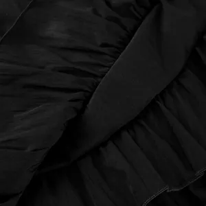 Close-up of ruffled black fabric texture for a high-waisted tiered cake skirt design.