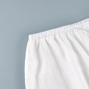 Detailed close-up showing the elastic waistband and drawstring on white semi-sheer pants