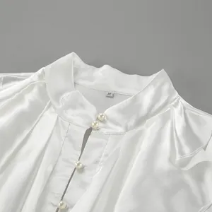 Detail view of white ruffled stand collar satin blouse with elegant pearl buttons