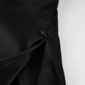 Detailed macro shot of the hidden side zipper on a black satin camisole top.