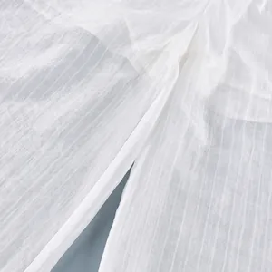 Macro view of semi-transparent white fabric with vertical stripe texture and sheen.