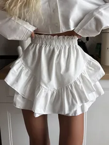 Close-up detail of white high-waisted tiered ruffle mini skirt with elastic waist