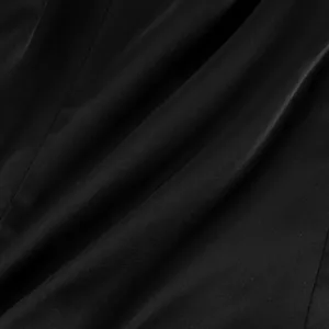 Macro view showing the smooth texture and soft folds of premium black apparel fabric