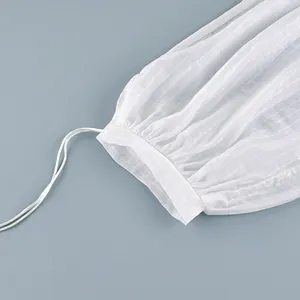 Close-up of white semi-sheer striped fabric with drawstring cuff detail