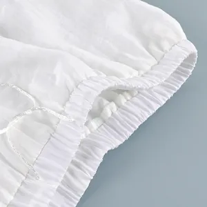 Close-up of elasticated ankle cuff and drawstring on white sheer summer trousers