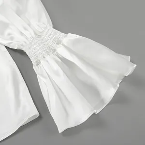 Detailed view of white French style lustrous shirt with elegant smocked flared sleeves