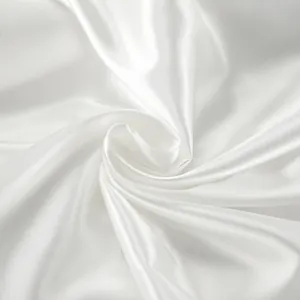 Detailed macro view of glossy white satin fabric showing smooth texture and luster