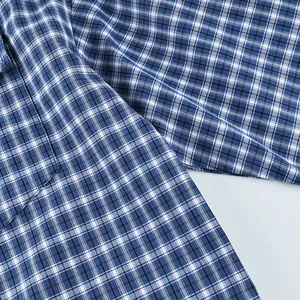 Detailed view of blue and white vintage plaid pattern texture on a soft cotton button-down shirt.