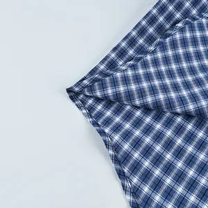 Detailed macro view of blue and white checkered cotton shirt fabric showing neat stitching.