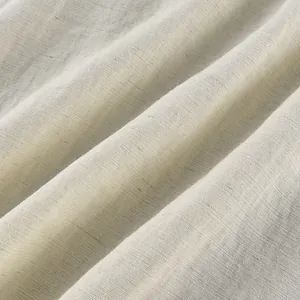 Close-up detail of high-quality off-white linen fabric with soft draped folds