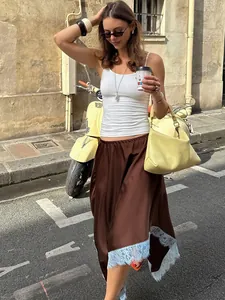 Chic brown satin midi skirt with delicate blue lace trim shown in an urban street setting